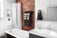 a contemporary bathroom with a red brick touch that makes it more industrial and more eye-catchy