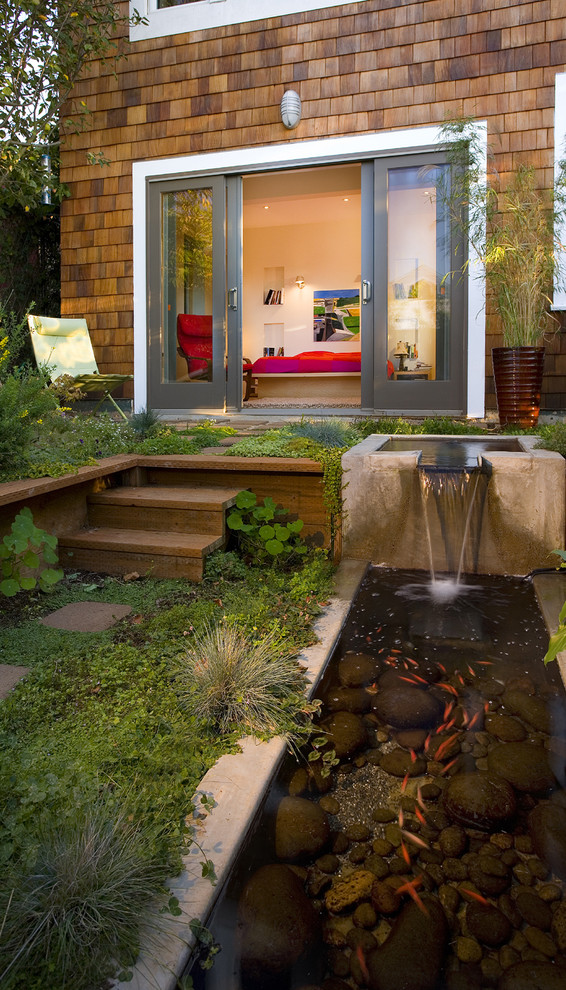 a contemporary patio with a koi pond and a little waterfall