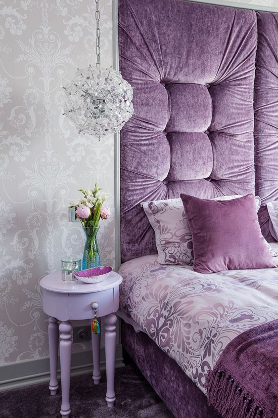 a glam bedroom with gray wallpaper, a purple bed built in a niche, a lavender nightstand and a crystal sphere pendant lamp