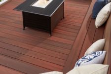 a laconic modern deck with a built-in bench, a coffee table with a drink cooler in the center and sculptural planters