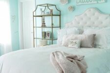 a lovely turquoise teen girl bedroom with a refined upholstered bed and pastel bedding, a brass storage unit and some art
