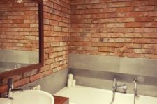 a minimalist meets industrial bathroom with red bricks, grey tiles and a rich-toned vanity