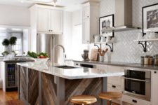 a pallet wood chevron clad kitchen island with a white countertop stands out in this neutral kitchen and adds a rustic feel