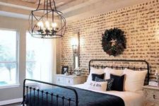 a rustic meets vintage bedroom with a faux brick wall, a forged chandelier and elegant dressers