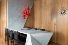 a sculptural concrete kitchen island and dining table that is extended to the wall makes a statement