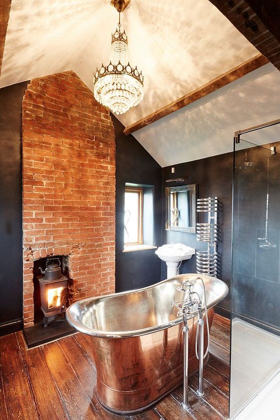 a vintage-inspired industrial bathroom with red brick, graphite grey tiles and wooden floors looks really cool