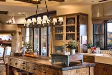 a vintage rustic kitchen with shaker style cabinets, a wooden beam ceiling, an oversized stained kitchen island with storage compartments