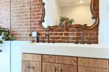 a wall partly done with red brick makes the bathroom more eye-catchy, a bit industrial and cool