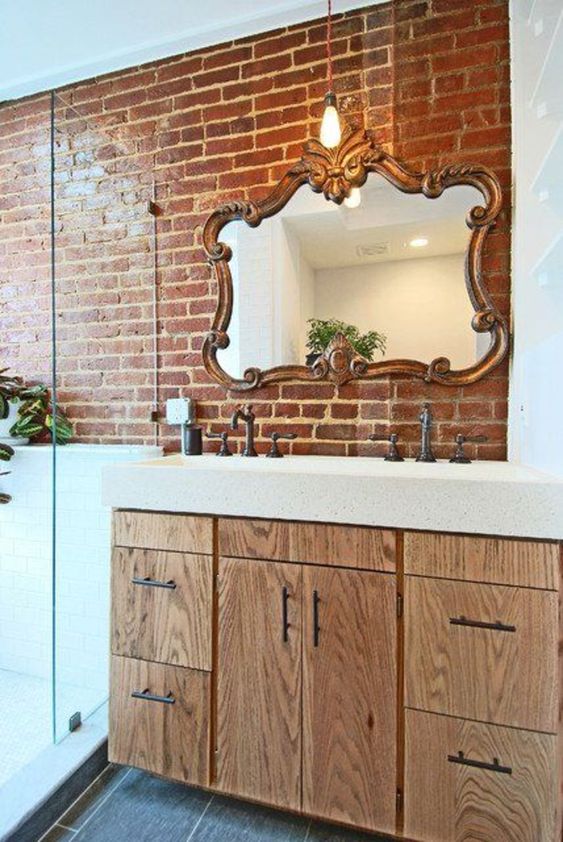 a wall partly done with red brick makes the bathroom more eye-catchy, a bit industrial and cool