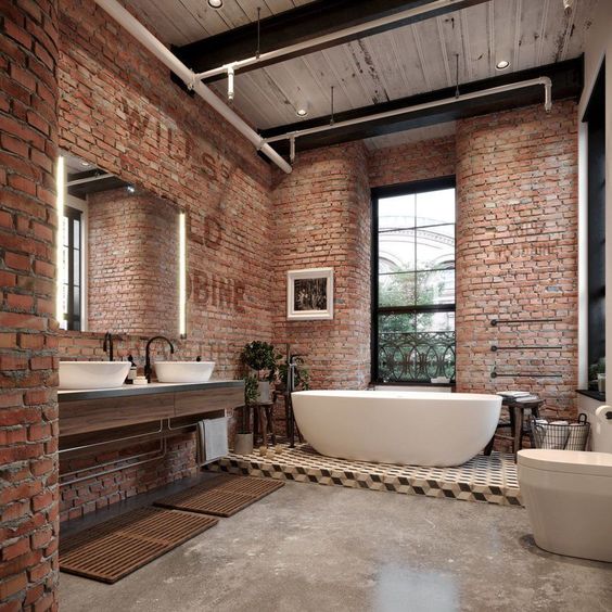 an industrial bathroom done with red bricks, a concrete floor, a tiled platform and chic modern appliances