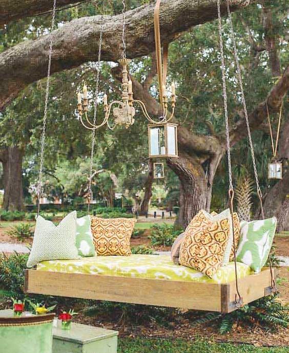 an outdoor hanging bed for one, some lanterns and ropes for decor and printed pillows is a bright idea