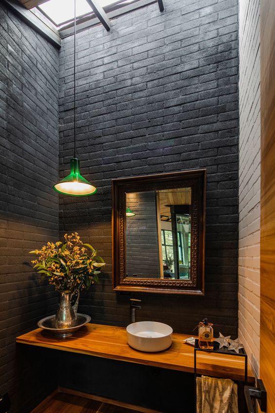 Black and white bricks, a light colored floating vanity and a mirror in a refined frame is a very cool and chic idea