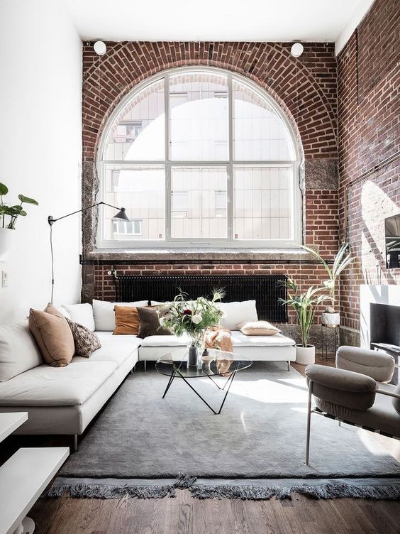 make your living room more luxurious with red brick, arched windows and a variety of textiles