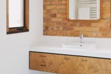 red brick paired with green geometric tiles, a light-colored vanity and a white countertop look chic and bold