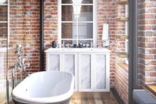 red brick walls and a wooden floor make an amazing combo, and a vintage tub and vanity add chic