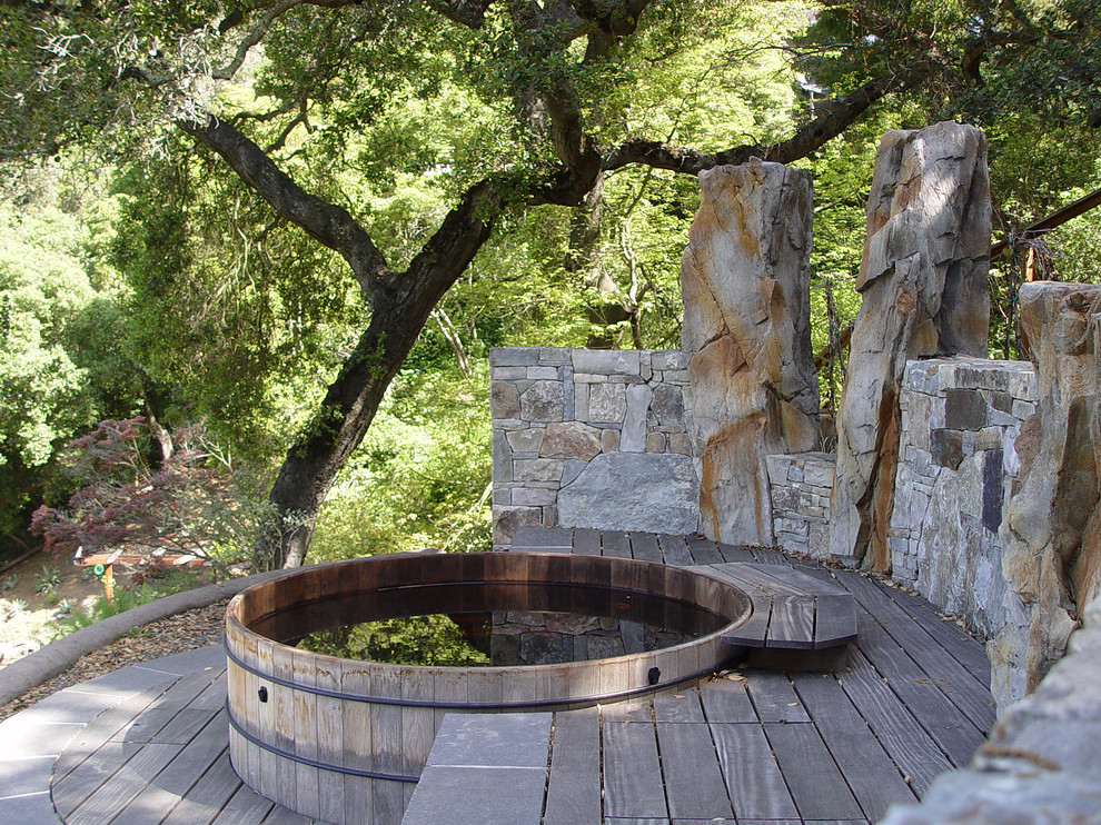 this rustic deck is a great example of how well a stone wall match a redwood hot tub tucked among the tree  (Simmonds & Associates, Inc.)