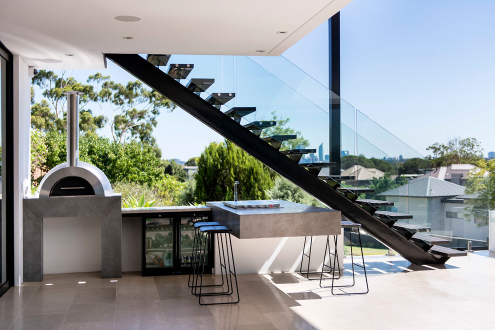 This contemporary entertaining area hides a little kitchen under a modern staircase.