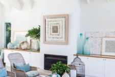 a beach living room with touches of blue and turquoise, printed furniture, a driftwood chandelier and an artwork