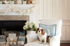a beach mantel with a seashell and urchin wreath, potted blooms, large shells and a seashell and starfish garland