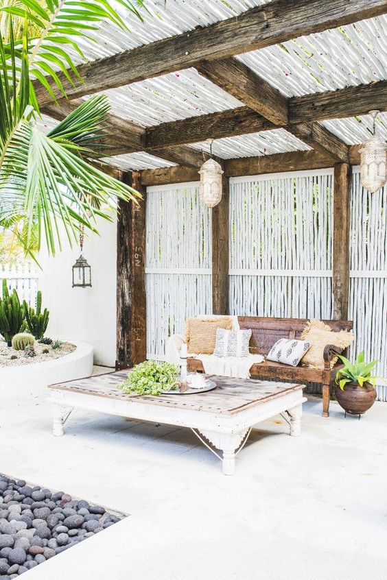 a beach terrace with vintage wooden furniture, Moroccan lamps, potted greenery, cacti and other plants is very relaxed