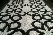 a bold black and white pebble garden path with a catchy pattern is a mosaic decoration