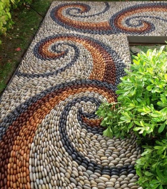 a bright pebble path with blue, white, burgundy and rust pebbles and swirl patterns