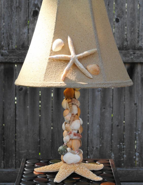 a cool table lamp of seashells covering the base, a starfish at the base and a neutral lampshade accented with a starfish