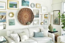 a cozy beach living room with white upholstered furniture, a large gallery walls with photos, artworks and a decorative basket