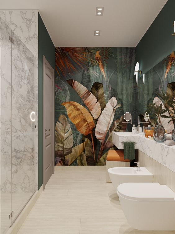 a modern tropical bathroom with a statement dark tropical mural, a marble vanity and shower plus built-in lights