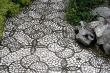 a monochromatic pebble garden path done with catchy floral-inspired patterns with black borders and white pebbles