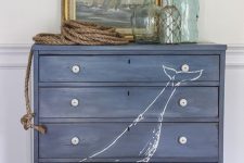 a navy dresser with a whale is a lovely idea for a nautical or coastal space, it will add color and interest
