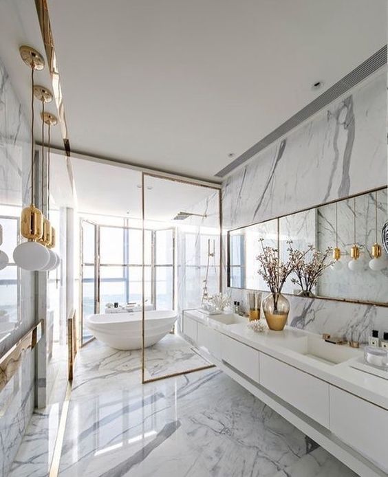 a refined white marble bathroom with a glazed wall, a tub, a mirror and pendant lamps and a floating vanity