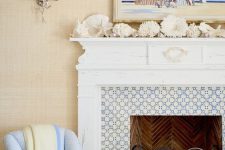 a seaside mantel with corals, starfish, seashells, driftwood and a bright beachy artwork over the mantel