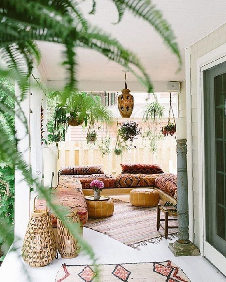a simple Moroccan space with hanging potted greenery, boho rugs, boho textiles and rattan lanterns