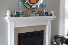 a simple and stylish beach mantel with driftwood balls, blue and white candles, glass candleholders and starfish