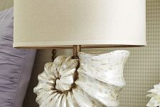 a statement table lamp featuring an oversized seashell and a plain lampshade is a gorgeous idea for any beachy space