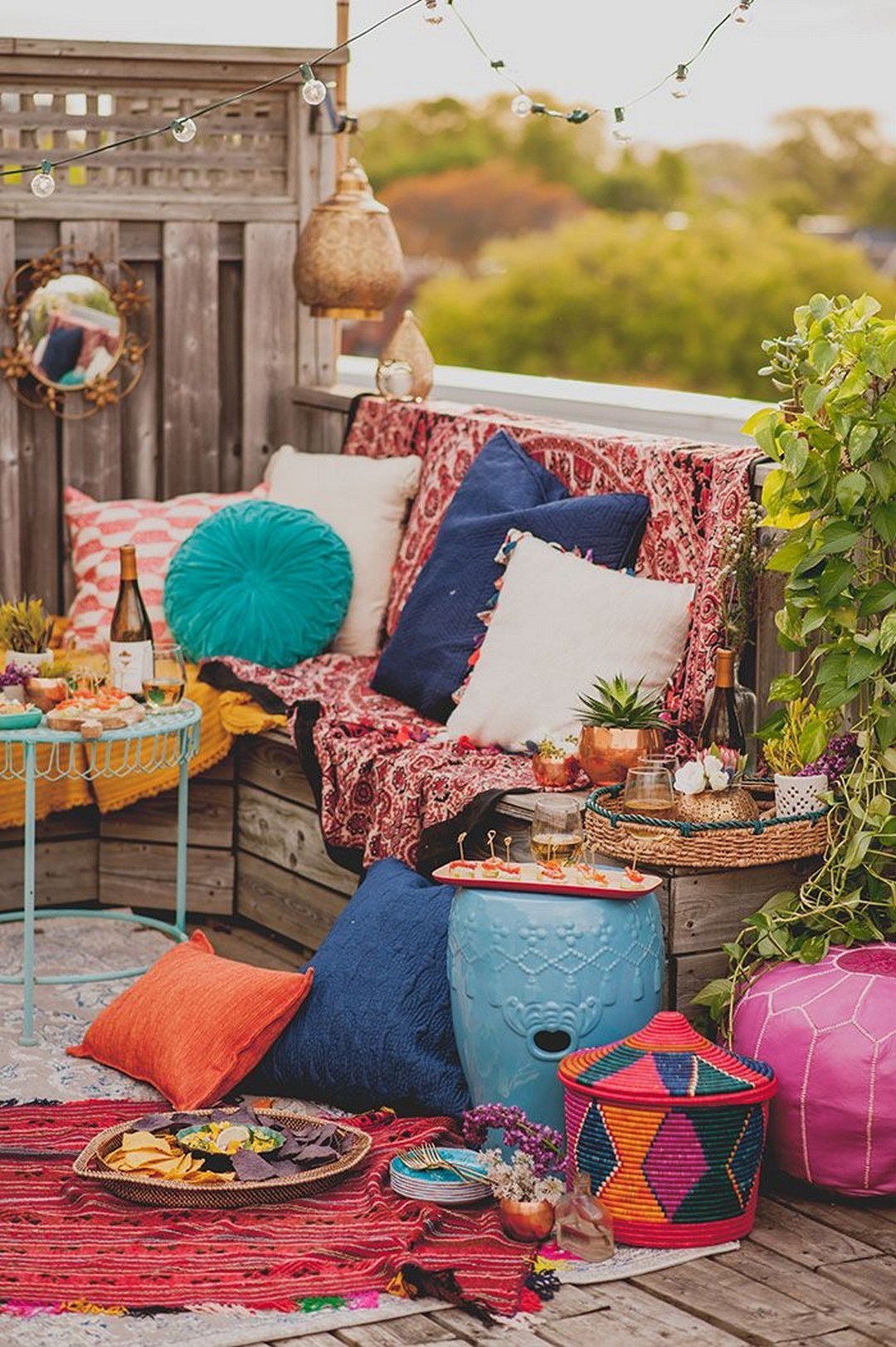 a super colorful Moroccan patio with bright pillows, blankets, rugs, baskets and ottomans plus a mirror and lights