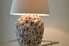 a table lamp with a base covered with seashells and a plain lampshade is a lovely idea for a seaside or beachy space
