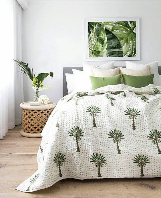 a tropical artwork, bedding and a carved wooden nightstand create a mood and a feeling in this tropical space
