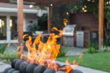 a unique fire bowl as an installation of pebbles, stone balls is a lovely idea for a contemporary outdoor space
