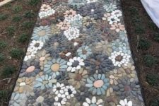 a very eye-catchy pebble garden pathway with muted pebbles and floral patterns all over is a real masterpiece