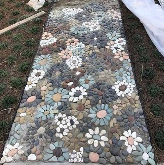 A very eye catchy pebble garden pathway with muted pebbles and floral patterns all over is a real masterpiece
