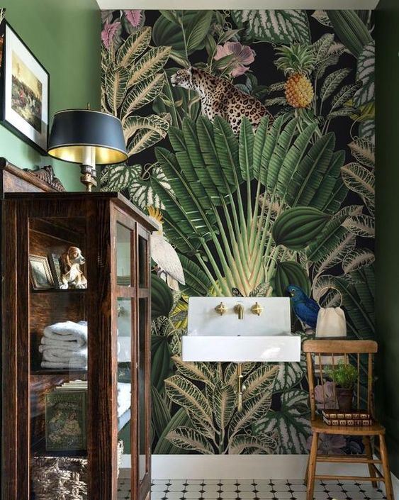 a vintage tropical bathroom with a catchy mural wall, a vintage glass armoire for storage and gold accents
