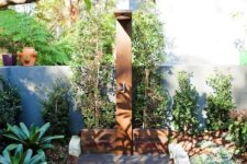 a welcoming outdoor shower done with wood, rocks and planted greenery all around
