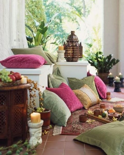 an exotic Moroccan patio done in green and pink, with potted greenery, lanterns and candle lanterns