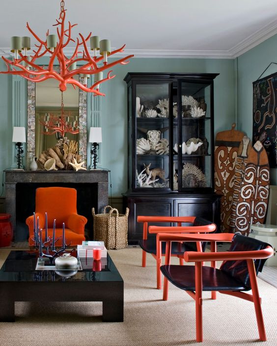 an orange coral-inspired chandelier that echoes with the chairs in the room helps it feel like the sea
