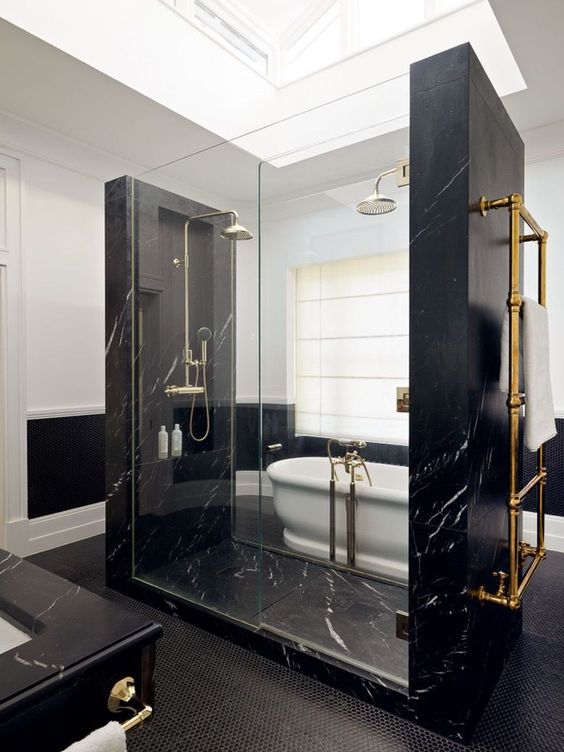 pure elegance and drama in this bathroom done with black marble, blakc penny tiles and a white vintage tub