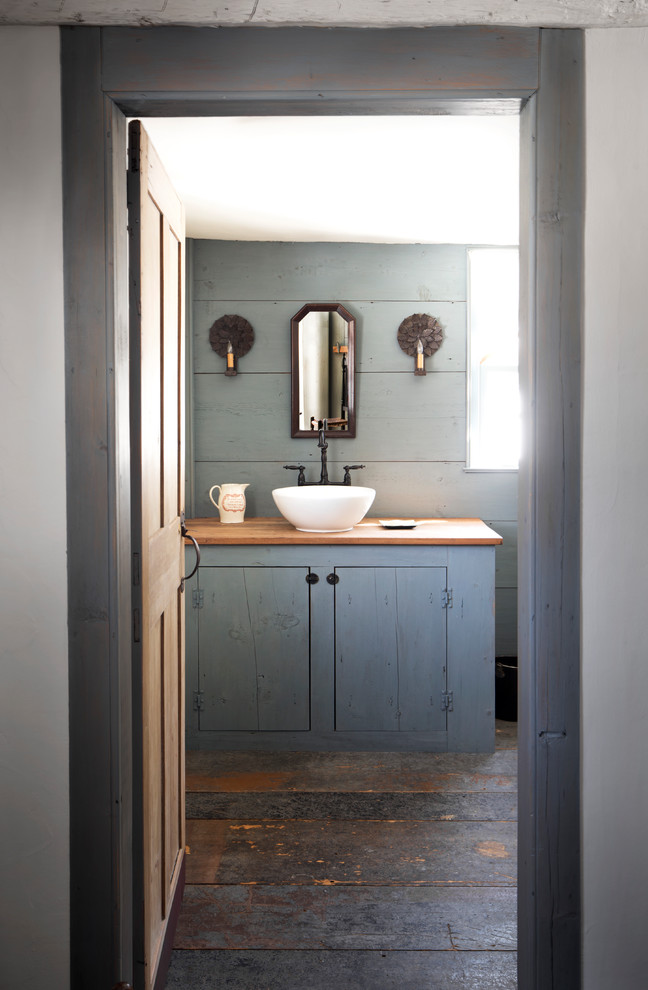a slate grey bathroom with a weathered wooden floor and a vanity in grey and a grey wall  (Tim Lenz Photography)