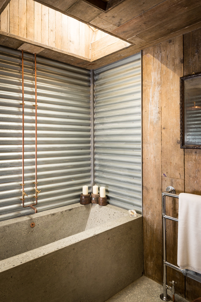 an industrial meets rustic bathroom with concrete, corrugated steel and wood (Unique Home Stays)