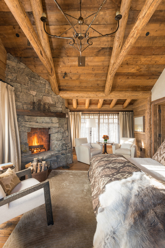 A fireplace clad with natural stone is one of the best features you could have in a rustic bedroom. Just make sure you have one or two comfy chairs near by.